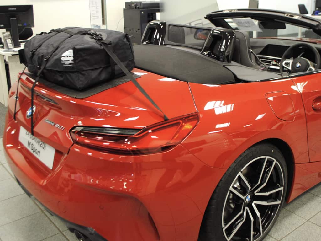 red 2.0i bmw z4 g29 with the hood doen in a bmw showroom and a boot-bag luggage rack fitted