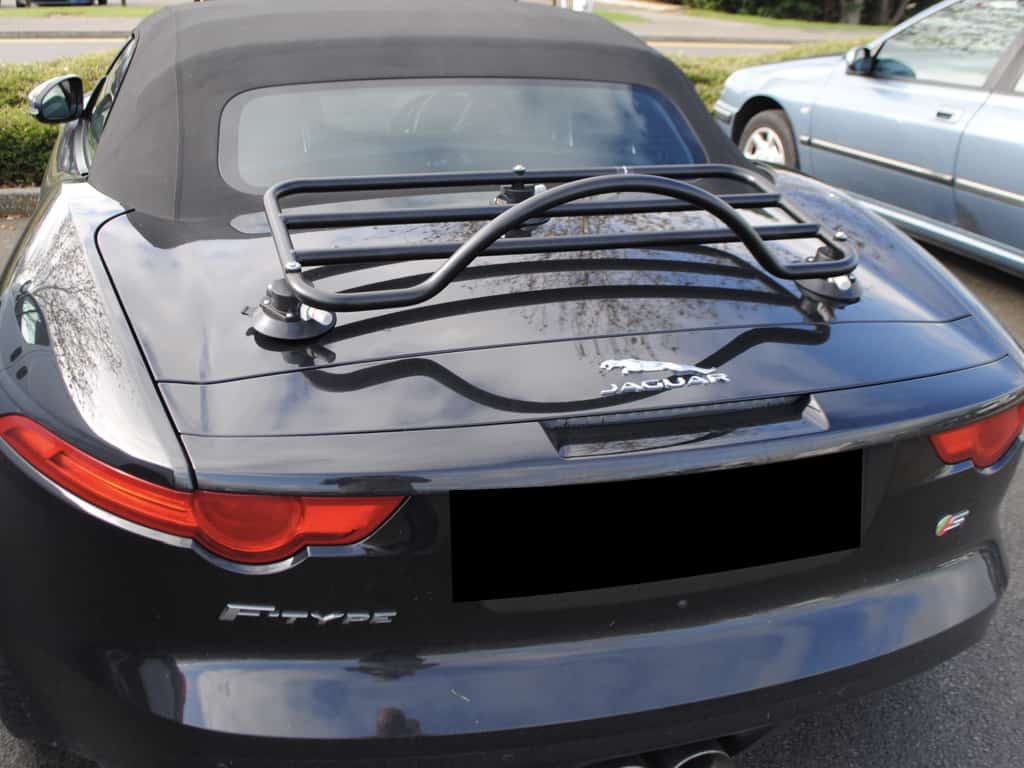black jaguar f type convertible with a black luggage rack fitted photographed from behind