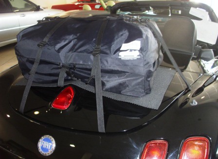 black fiat barchetta with a boot-bag original luggage rack fitted in a car showroom