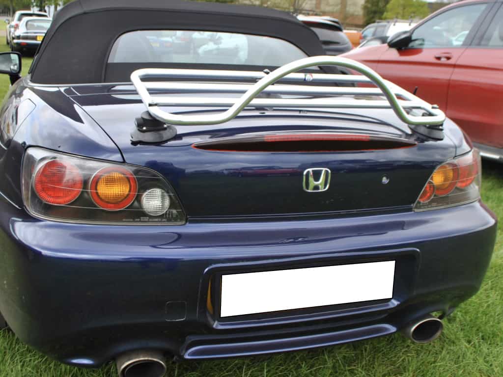 rear view of a dark blue honda s2000 in a field with a stainless steel luggage rack fitted 