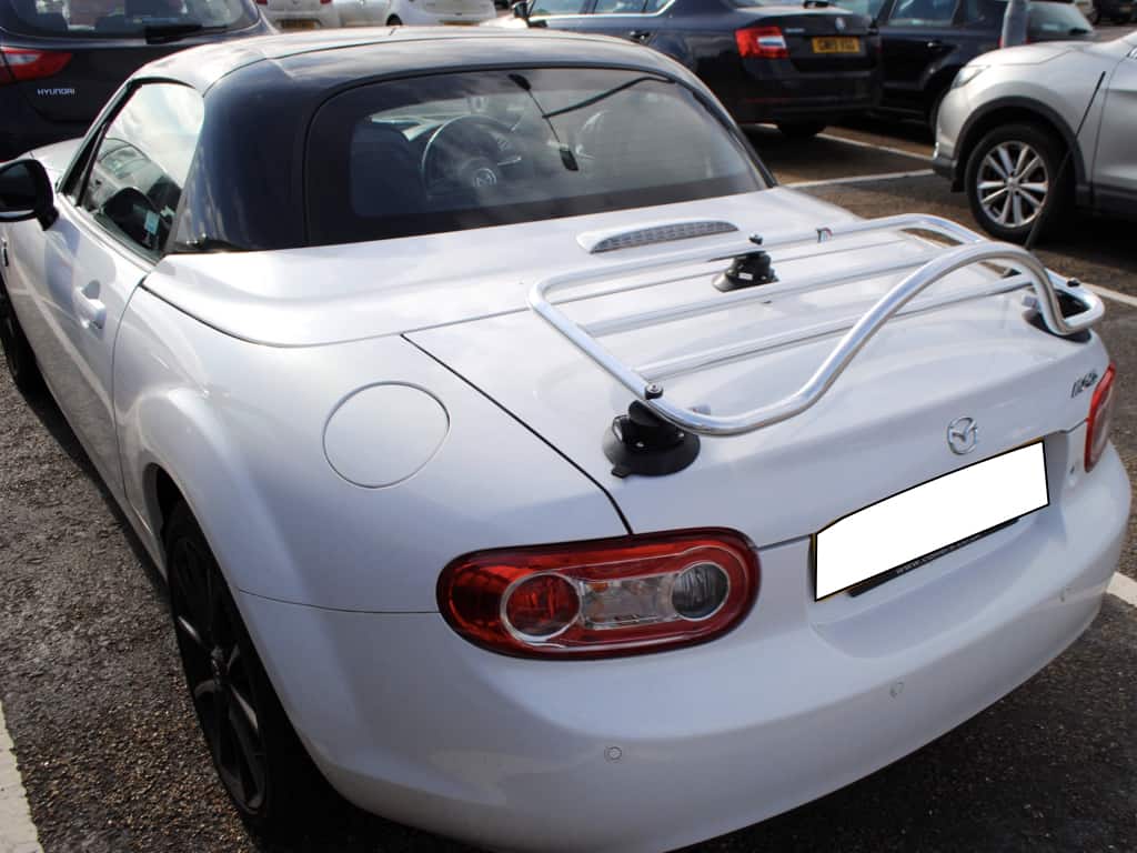 revo-rack luggage rack fitted to a white mazda mx5 mk3 roadster with a black roof