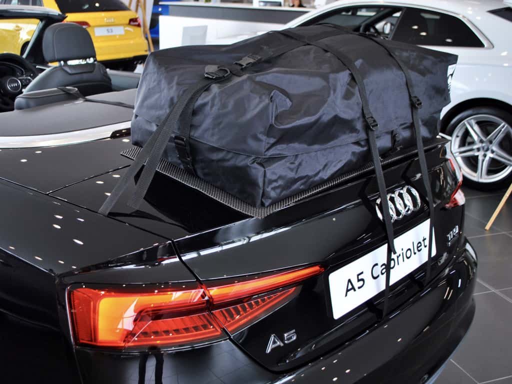 black audi a5 convertible with a boot-bag luggage rack fitted hood down in a audi showroom