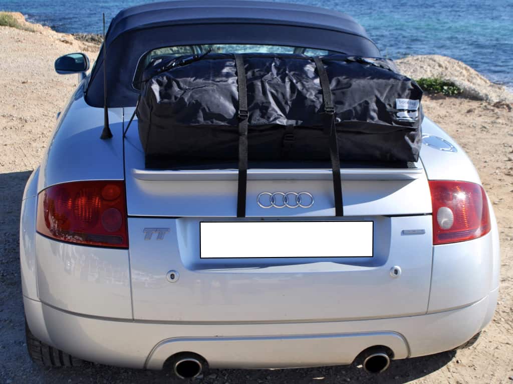 silver audi tt mk1 with a boot-bag vacation luggage rack fitted next to the sea on a cliff.