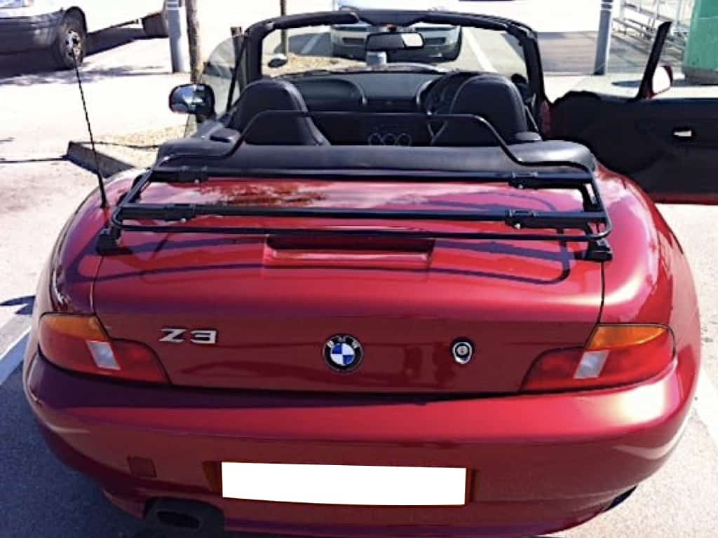 burgundy bmw z3 with the hood down on a sunny day and a black luggage rack fitted