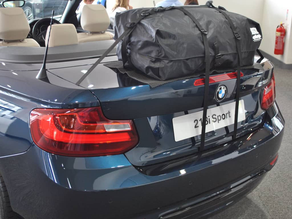 blue bmw 218i sport convertible with the hood down and a boot-bag original fitted to the boot