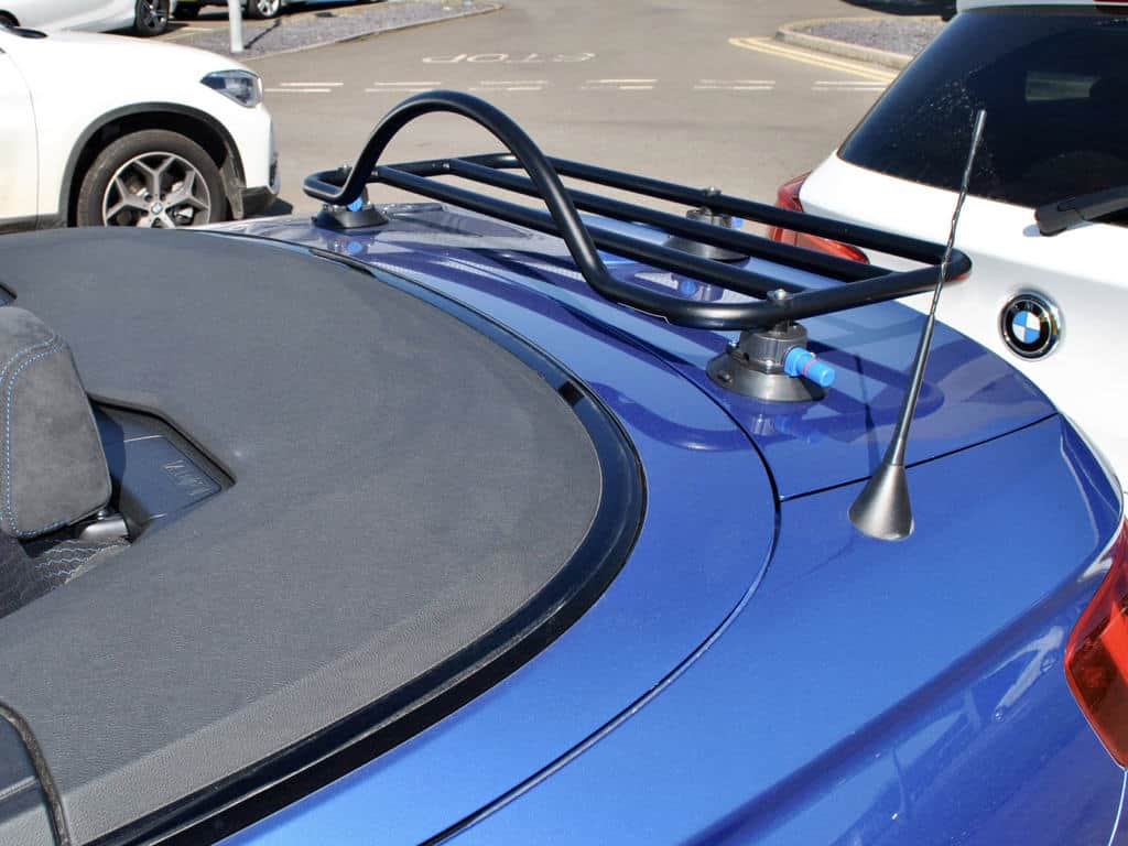 rear view of a bmw 2 series cabriolet in blue with a black luggage rack fitted to the boot hood down