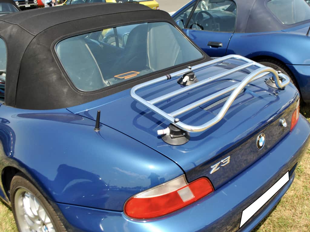blue bmw z3 with a chrome luggage rack fitted on a sunny day