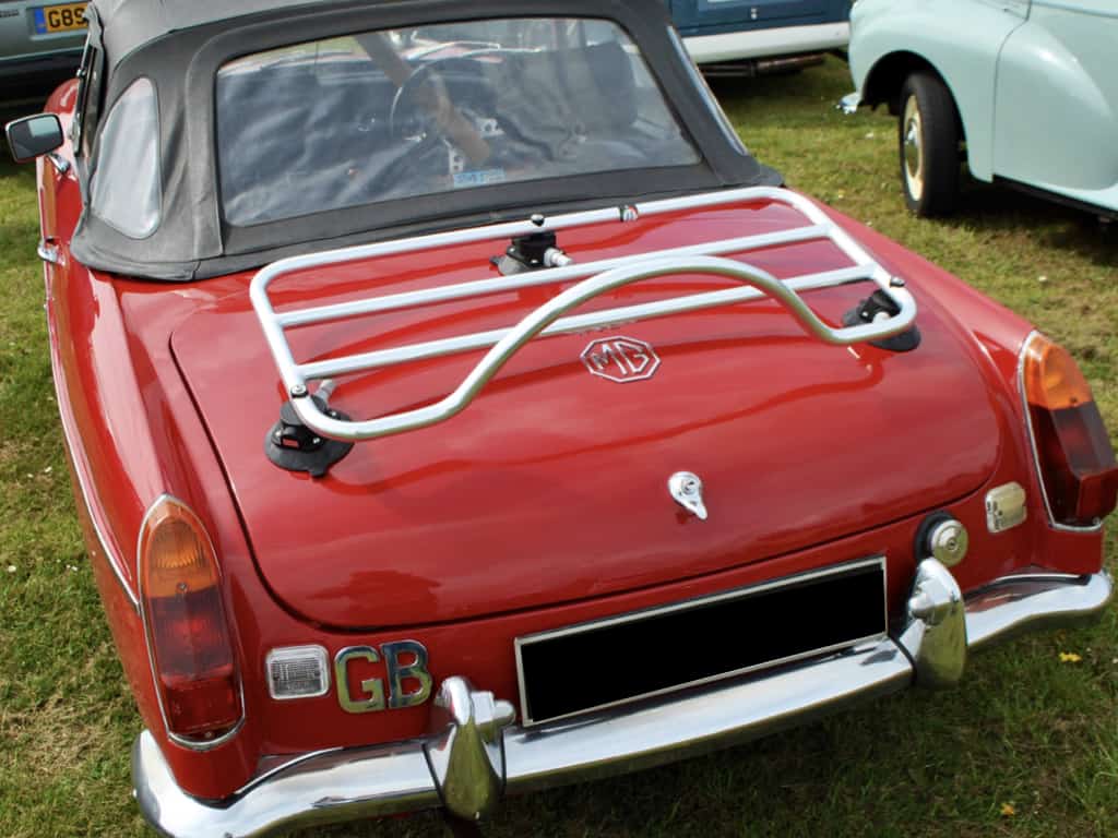 red mgb with a black hood and a revo-rack luggage rack fitted at a car show