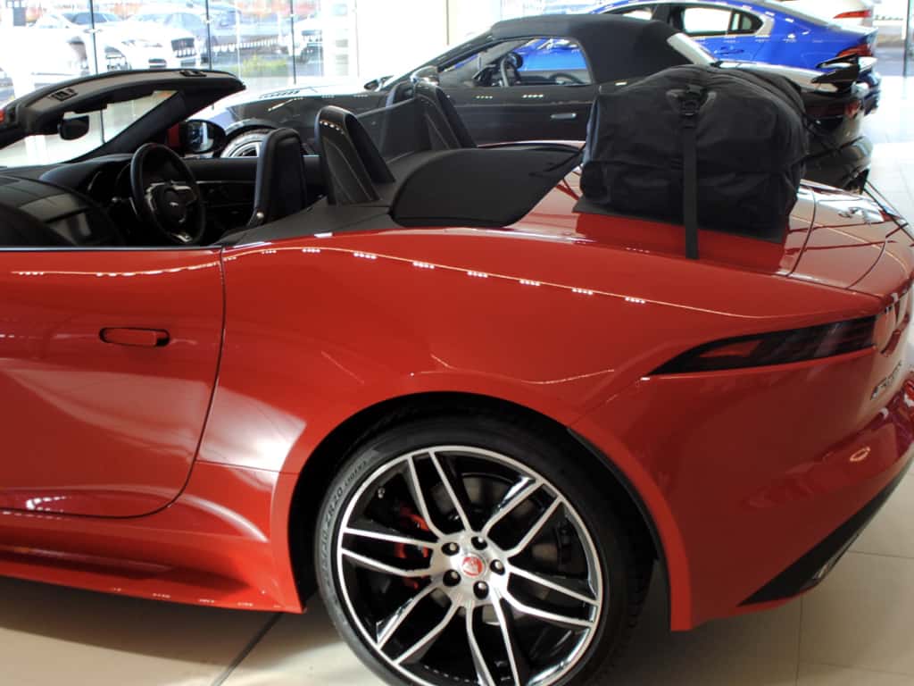 side view of a boot-bag vacation luggage rack fitted to a red Jaguar f type