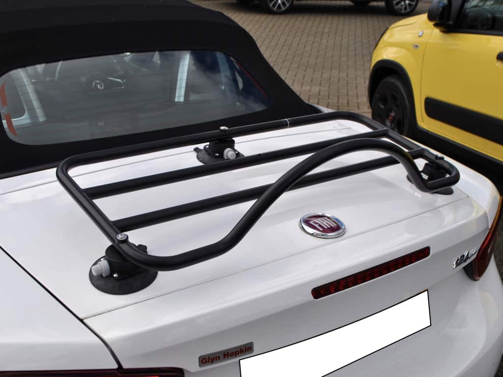 white fiat 124 spider with a black revo-rack luggage rack fitted photographed close from above.