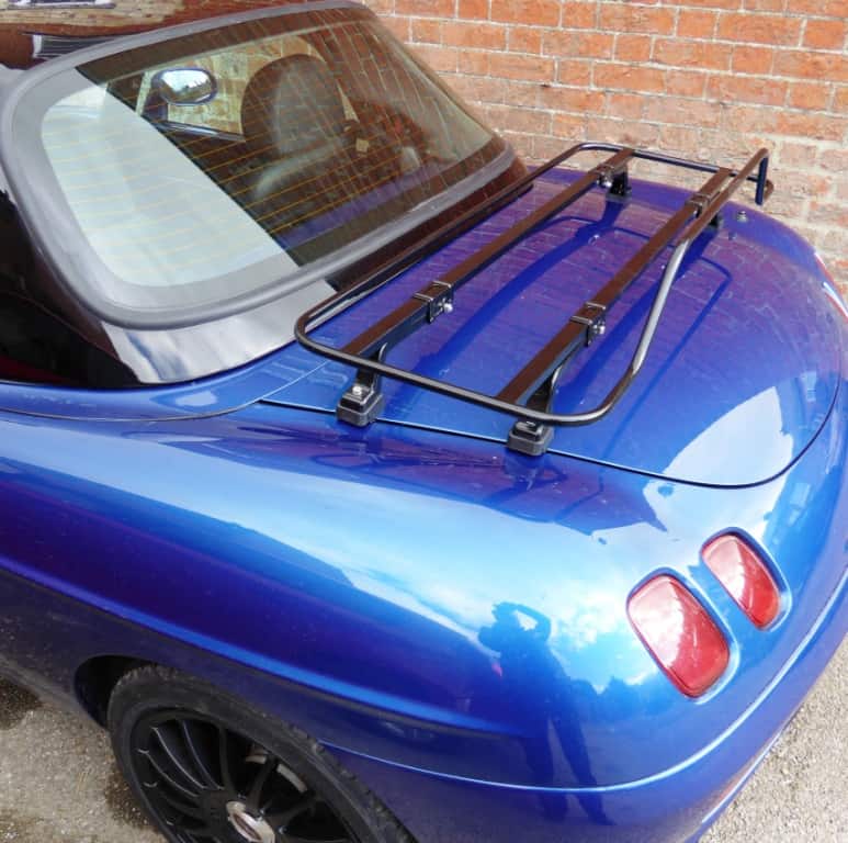 blue fiat barchetta with a black hardtop and a luggage rack fitted to the boot photographed from the side