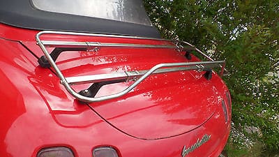 red fiat barchetta with a stainless steel luggage rack fitted photographed close from the side