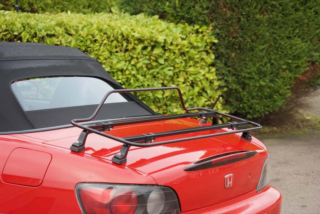 red honda s2000 next a hedge with a black luggage rack fitted