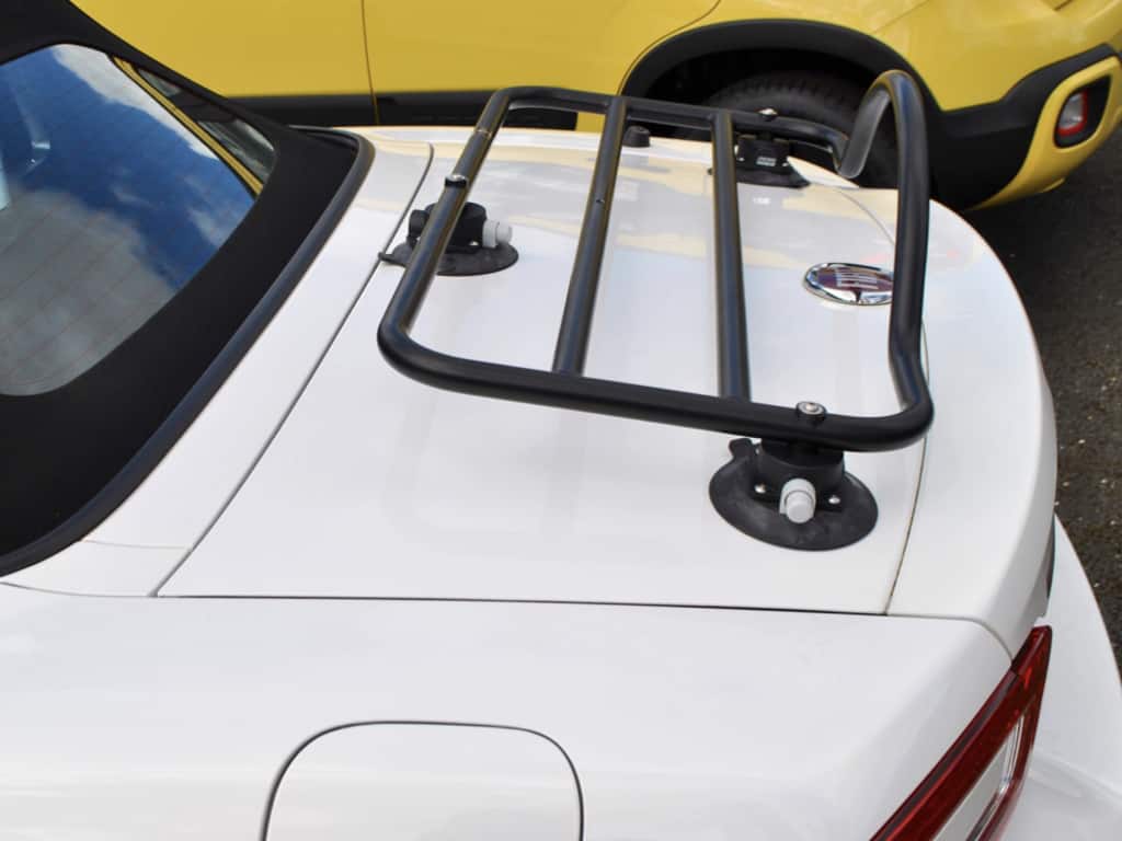 side view of a revo-rack black luggage rack fitted to a white fiat 124 spider at fiat milton keynes