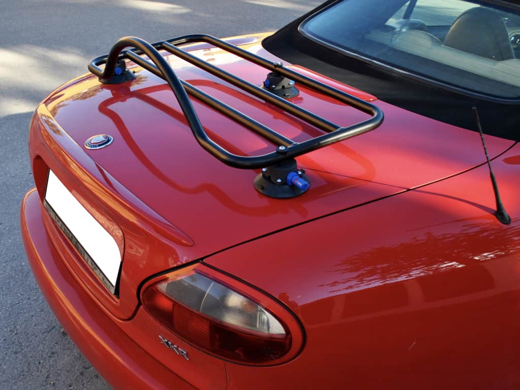Red Jaguar XK8 photographed from the side with a black luggage rack fitted to the boot lid