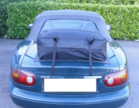 green mazda mx5 mk1 with a boot-bag original luggage rack fitted photographed from the rear
