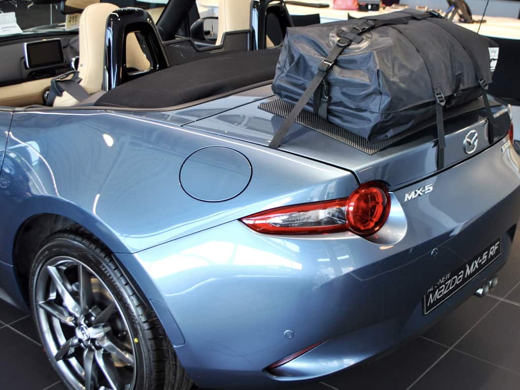 light metallic blue mazda mx5 mk4 with a boot-bag original luggage rack fitted in a mazda delaership