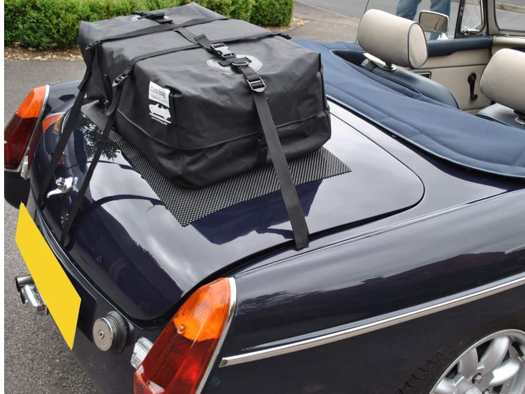 dark blue mgb with the hood down and a blue tonneau cover fitted with a boot-bag original luggage rack fitted