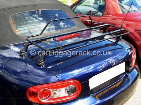 dark blue mazda mx5 mk3 on a very sunny day with a black luggage rack fitted
