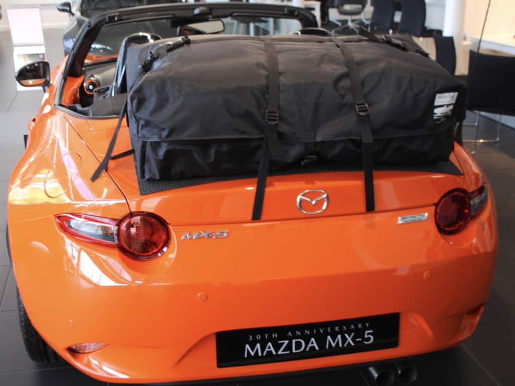 rear view of a orange 30th edition mazda mx5 mk4 with a boot-bag vacation fitted