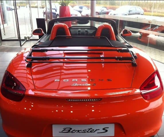 orange porsche boxster 981 with a black luggage rack fitted in Porsche Silvertones showroom