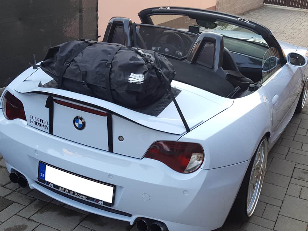 White BMW Z4 with spoiler with luggage carrier attached on driveway