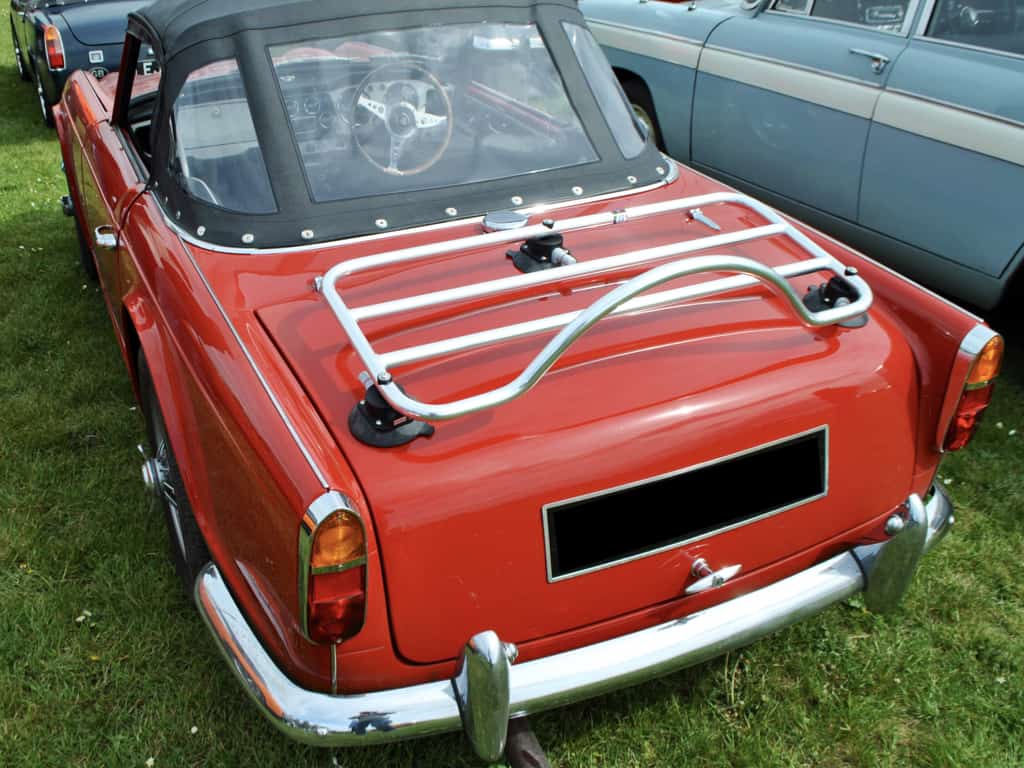 side view of a red triumph tr5 with a chrome luggage rack fitted