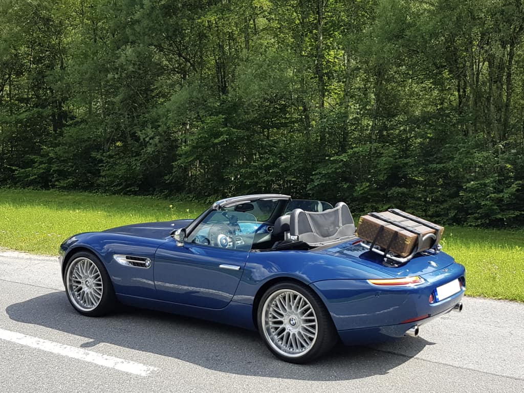 blue bmw z8 with the hood down next to a wood with a revo-rack black luggage rack fitted