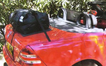 red mercedes benz slk r170 in the shade on a sunny day with a boot-bag original luggage rack fitted