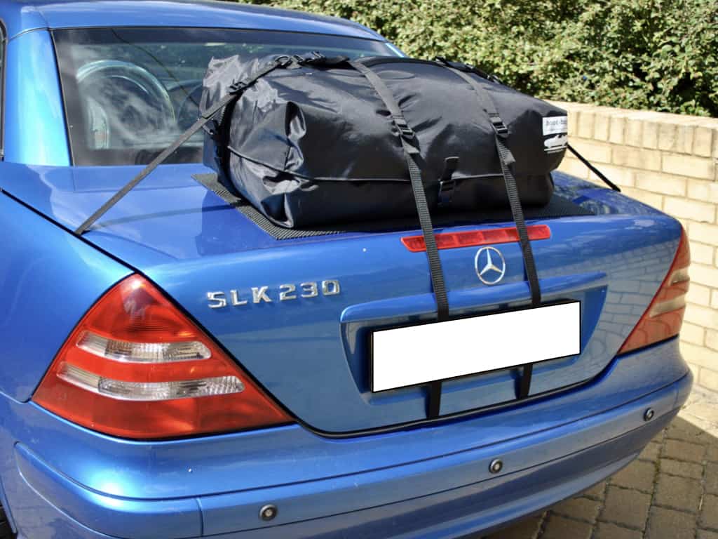 blue mercedes benz slk r170 with a boot-bag original luggage rack fitted on a sunny day