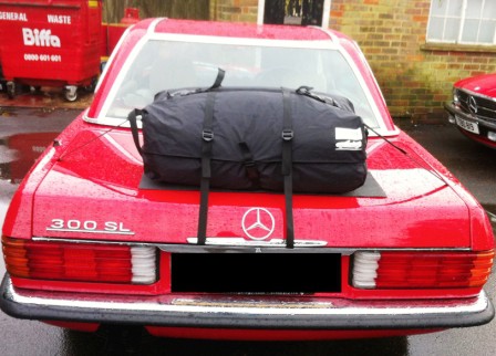 red mercedes sl r107 with a boot-bag original luggage rack fitted photographed from behind