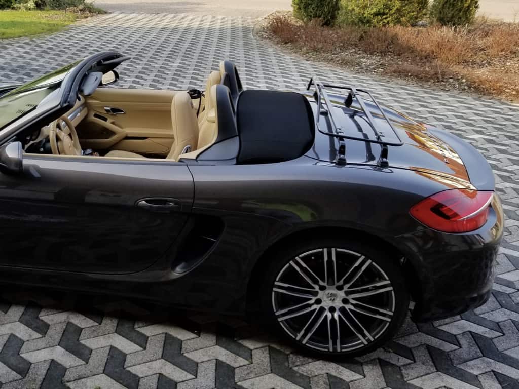 side view of a black porsche boxster 981 with a black luggage rack fitted