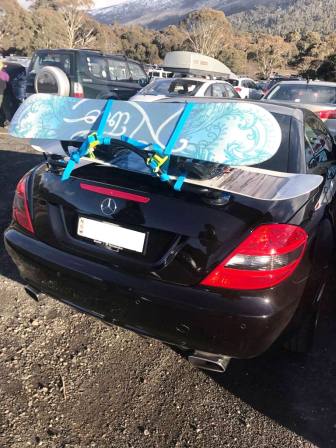 black mercedes slk r171 with a revo-rack luggage rack fitted carrying two snowboards