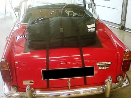 red triumph tr5 with the hood down and a boot-bag original luggage rack fitted 