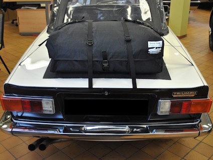 white triumph tr6 with a boot-bag original luggage rack attached 