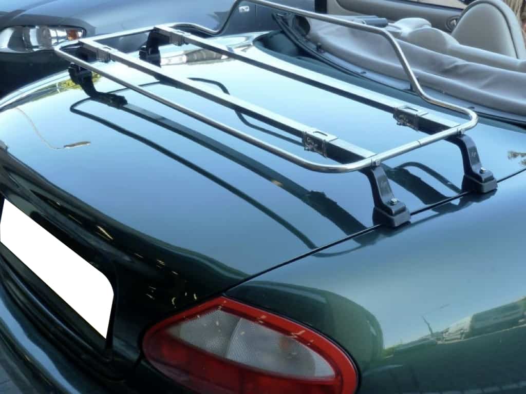 green jaguar xk8 convertible with a stainless steel luggage rack fitted to the boot, hood down