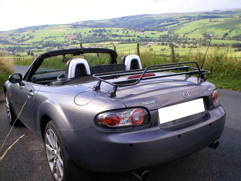 graphite mazda mx5 mk3 hood down with. black luggage rack fitted next to rolling hills 