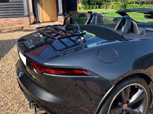 Grey jaguar f type convertible roof down with a black boot rack fitted