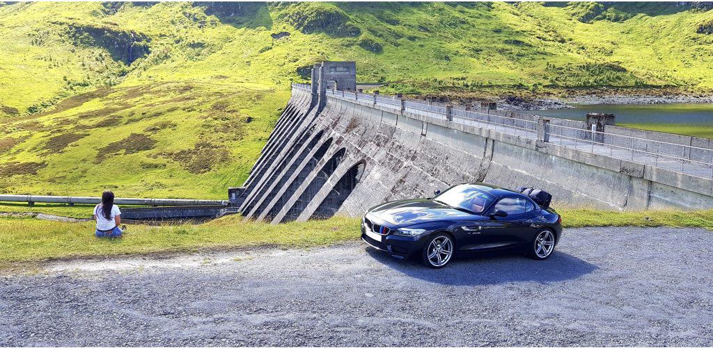 blue bmw z4 e89 next to a dam with a boot-bag luggage rack fitted 