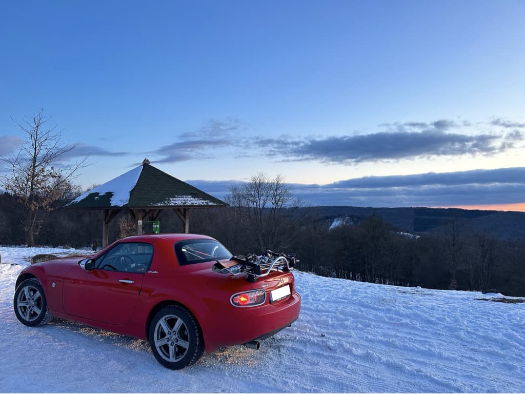 red mazda mx5 mk3 with a revo-rack pa luggage rack fitted carrying skis in the snow