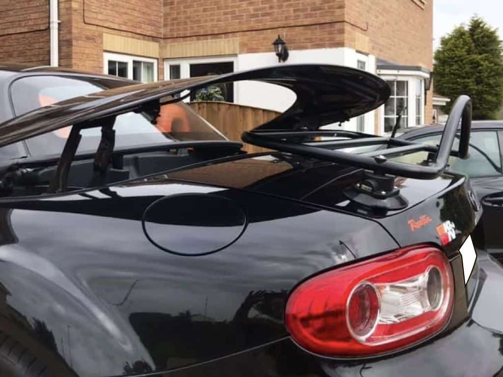 black mazda mx5 roadster coupe mk3 nc with a revo-rack black luggage rack fitted and the roof operating and not hitting the luggage rack