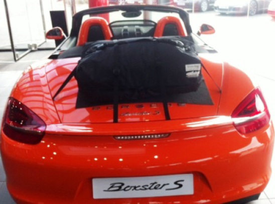 orange porsche boxster 981 in a Porsche garage with a boot-bag luggage rack fitted 