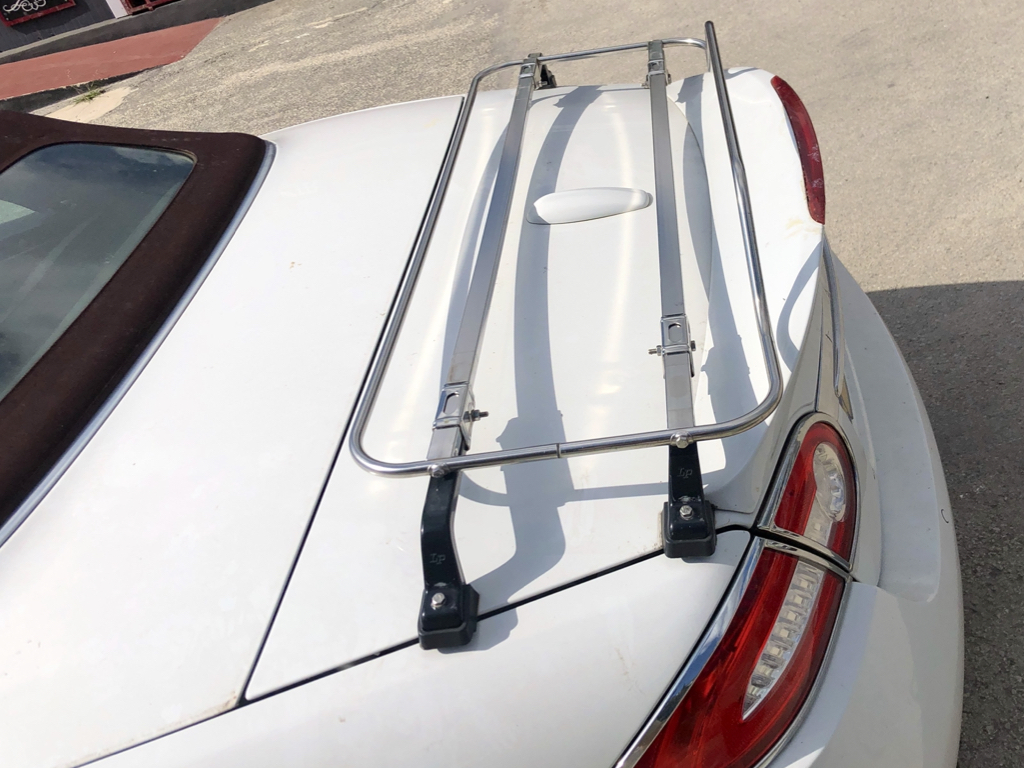 white Jaguar XK convertible with a stainless steel luggage rack fitted to the boot lid 