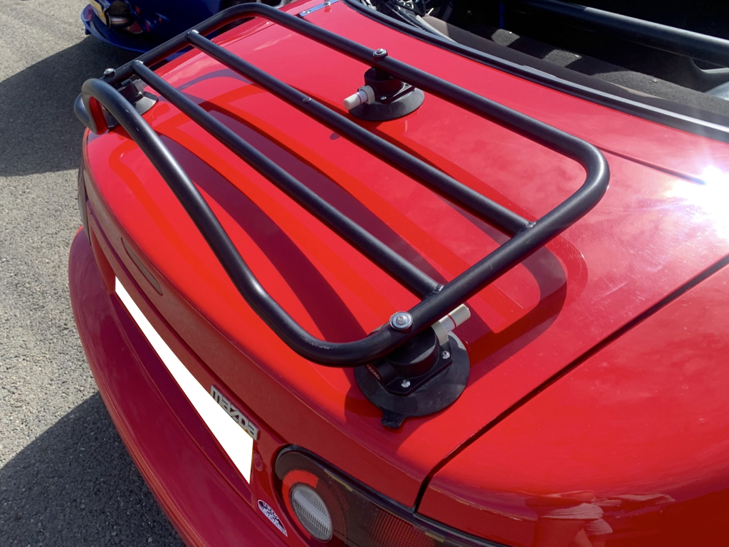 red mazda mx5 with a black luggage rack fitted photographed from the rear close up