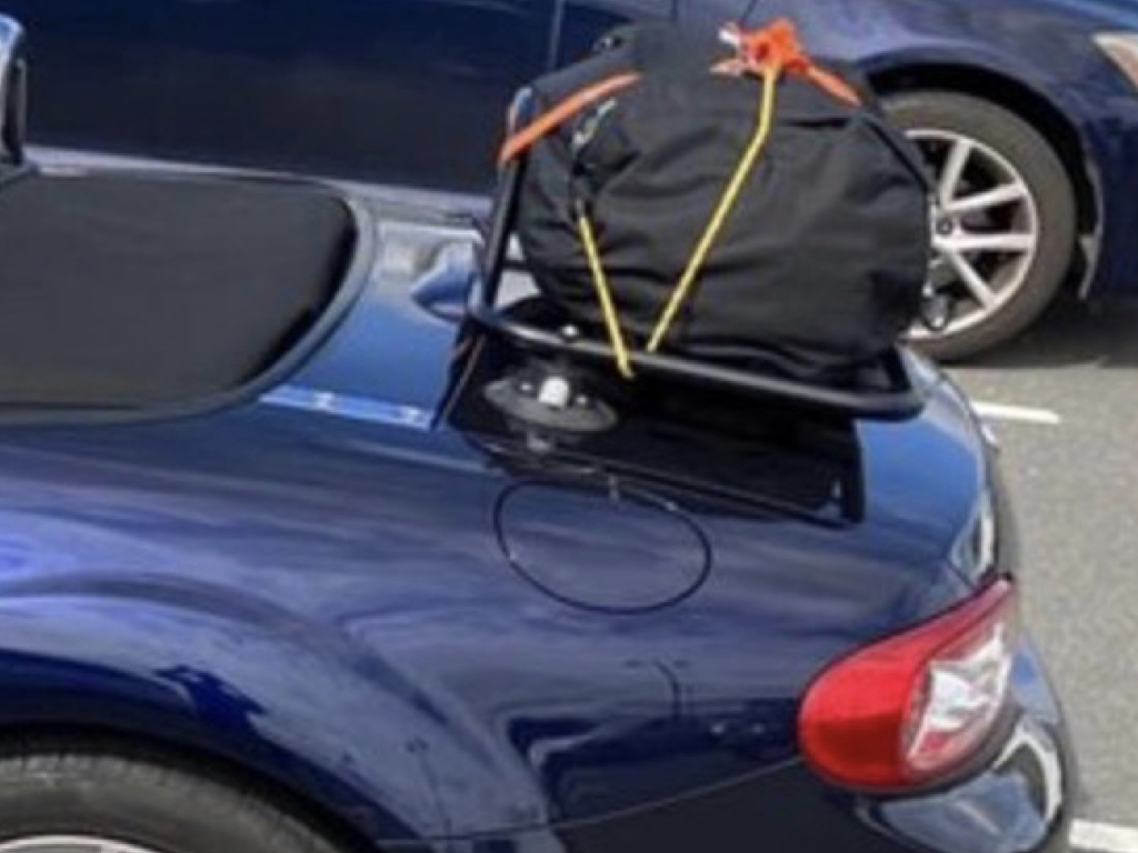 blue mazda mx5 mk3 with a revo-rack luggage rack fitted carrying a large black bag photographed from the side