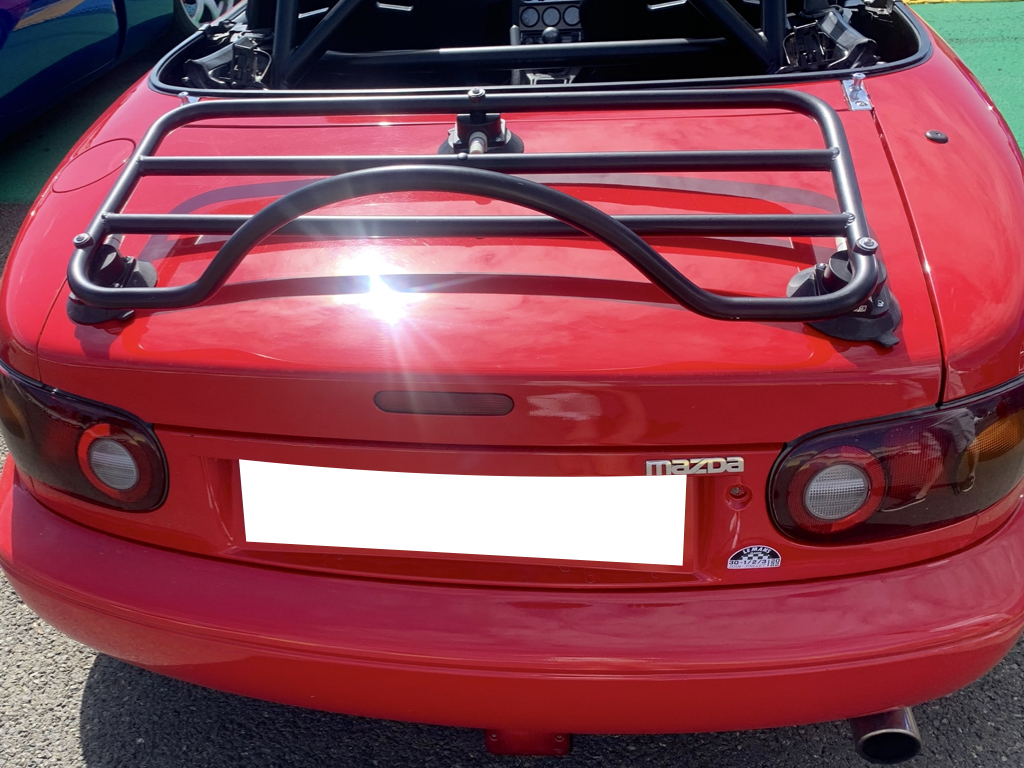 red mazda mx5 na mk1 with a revo-rack black luggage rack fitted photographed from the rear