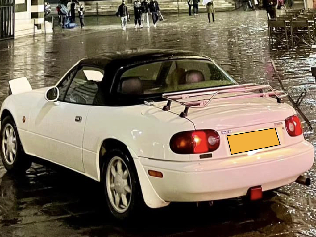white mazda mx5 mk1 na with a black roof and a stainless steel luggage rack fitted 