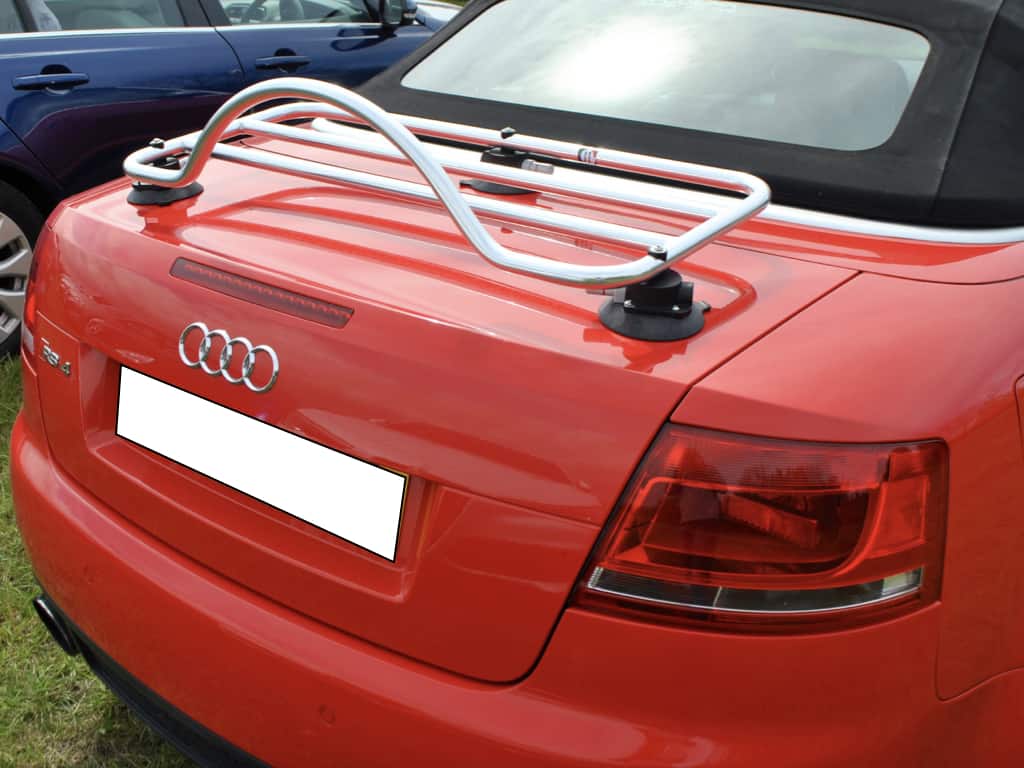 Red Audi A4 cabriolet with black hood up with modern chrome revo rack luggage rack attached
