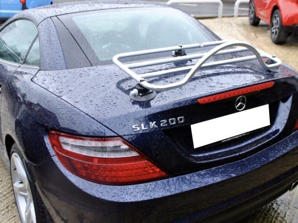 Blue Mercedes SLK R172 with chrome luggage rack attached on a rainy day