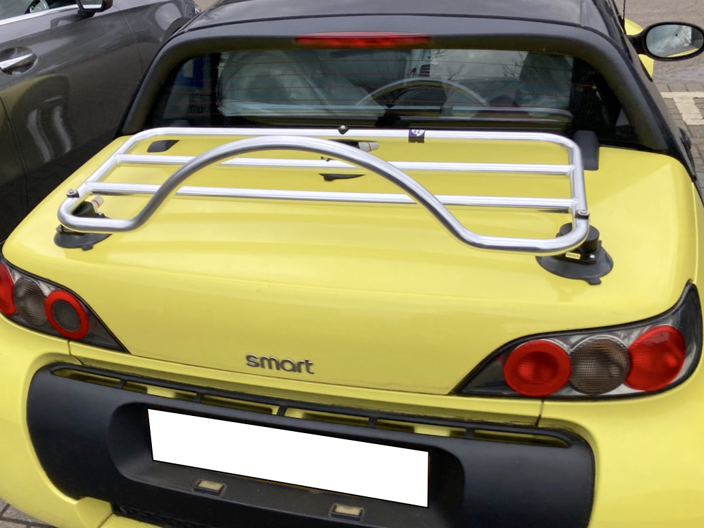 yellow smart roadster with a chrome boot rack fitted photographed close from the rear